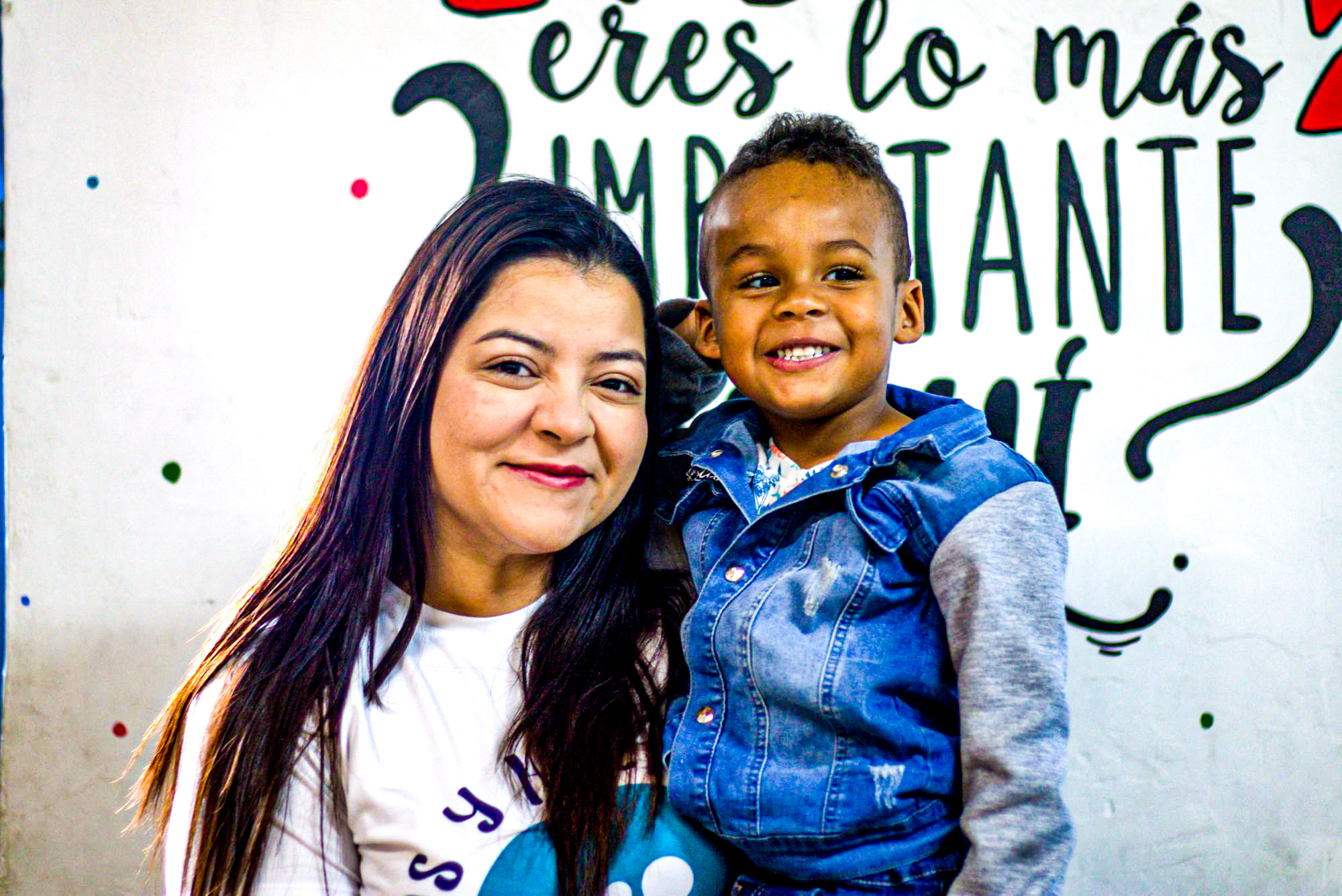 Lorena, the founder of Casa de Sueños, with a young child.