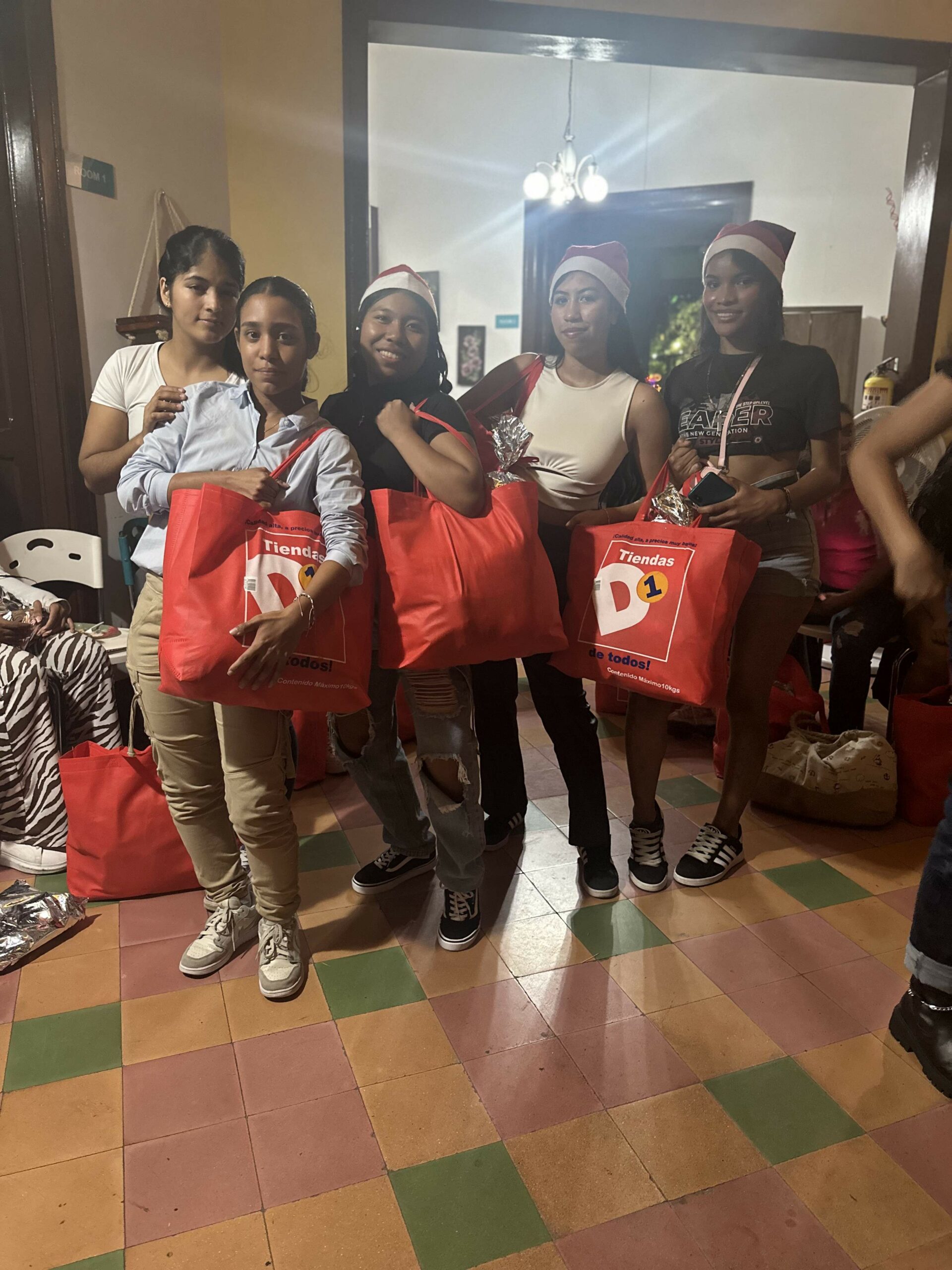 Young women with big red bags of Christmas gifts