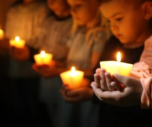 young children holding candles