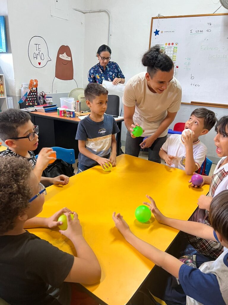 Oscar, teacher at Casa de Suenos, teaching children with balls.