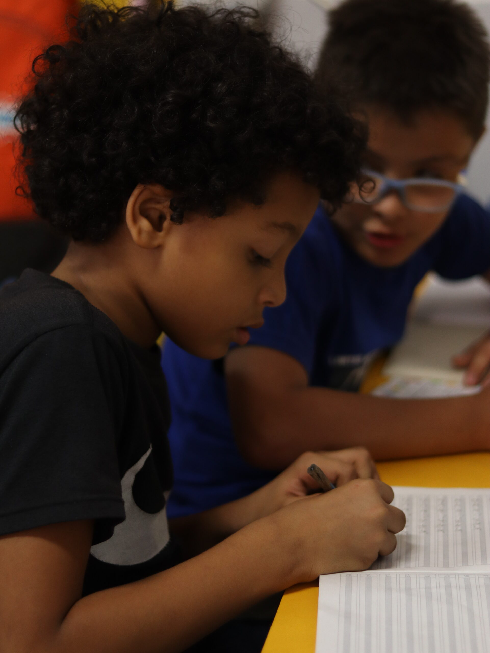 Mateo, one of many poor children in Medellin, working at lessons with another boy at Casa de Suenos.