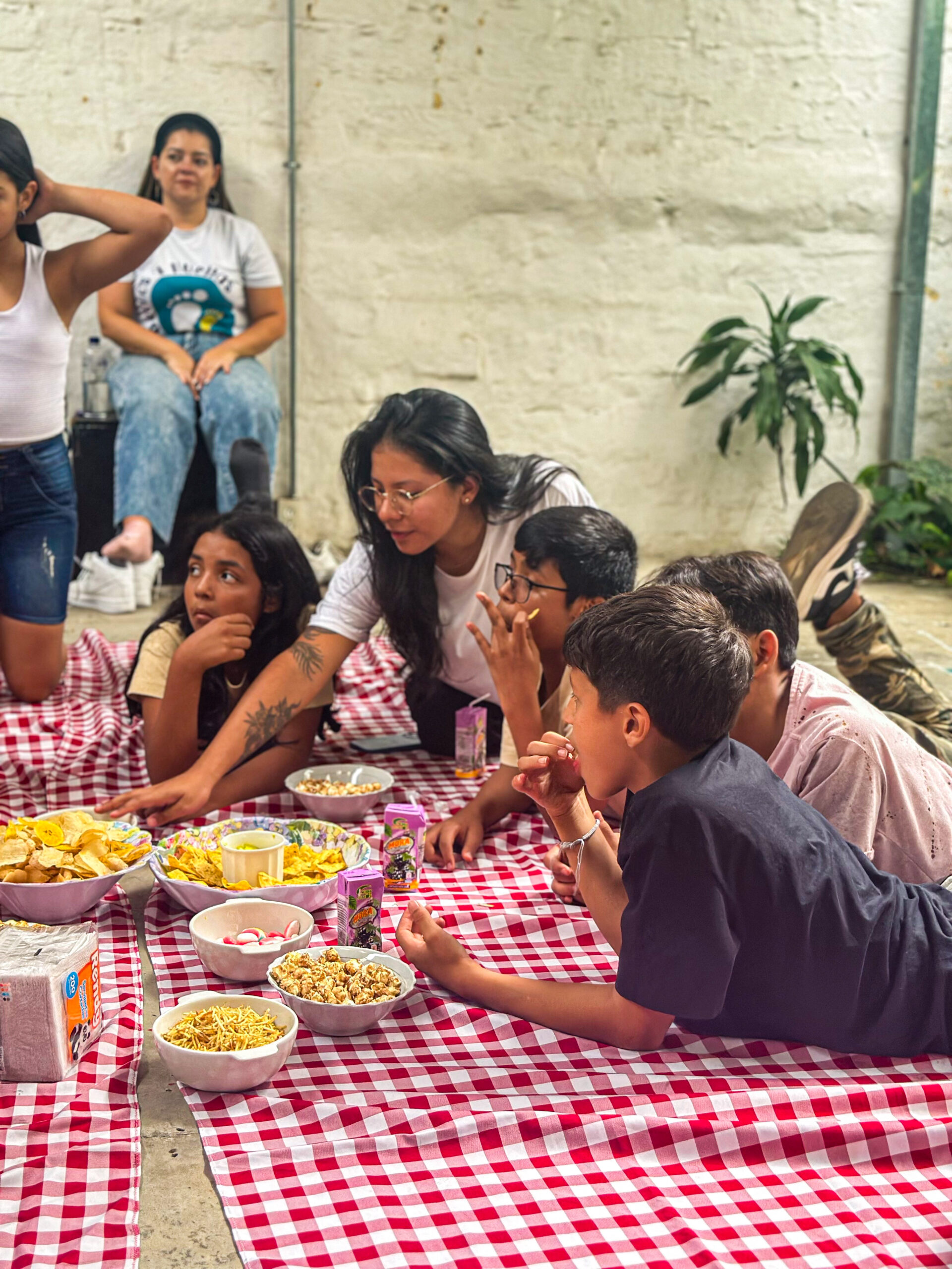 New Generation Teens at Casa de Suenos enjoying snacks and fellowship on a red checked tablecloth